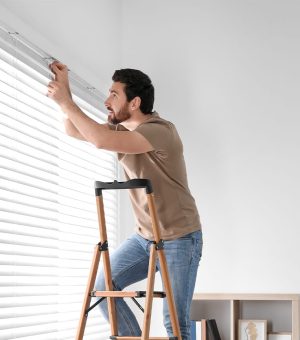 man installing window blind