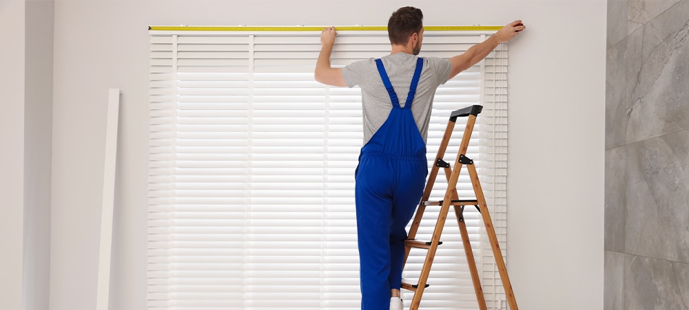 professional installing blinds in office