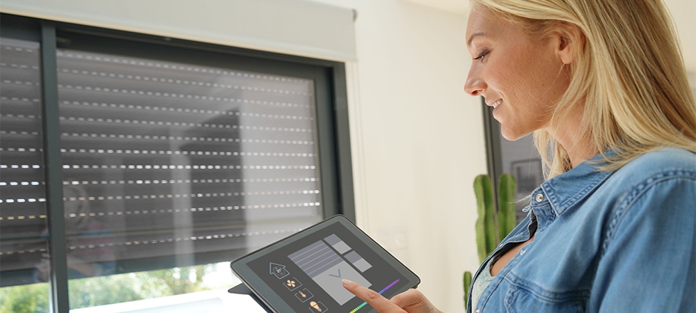 woman at home using smart automation system for blind control