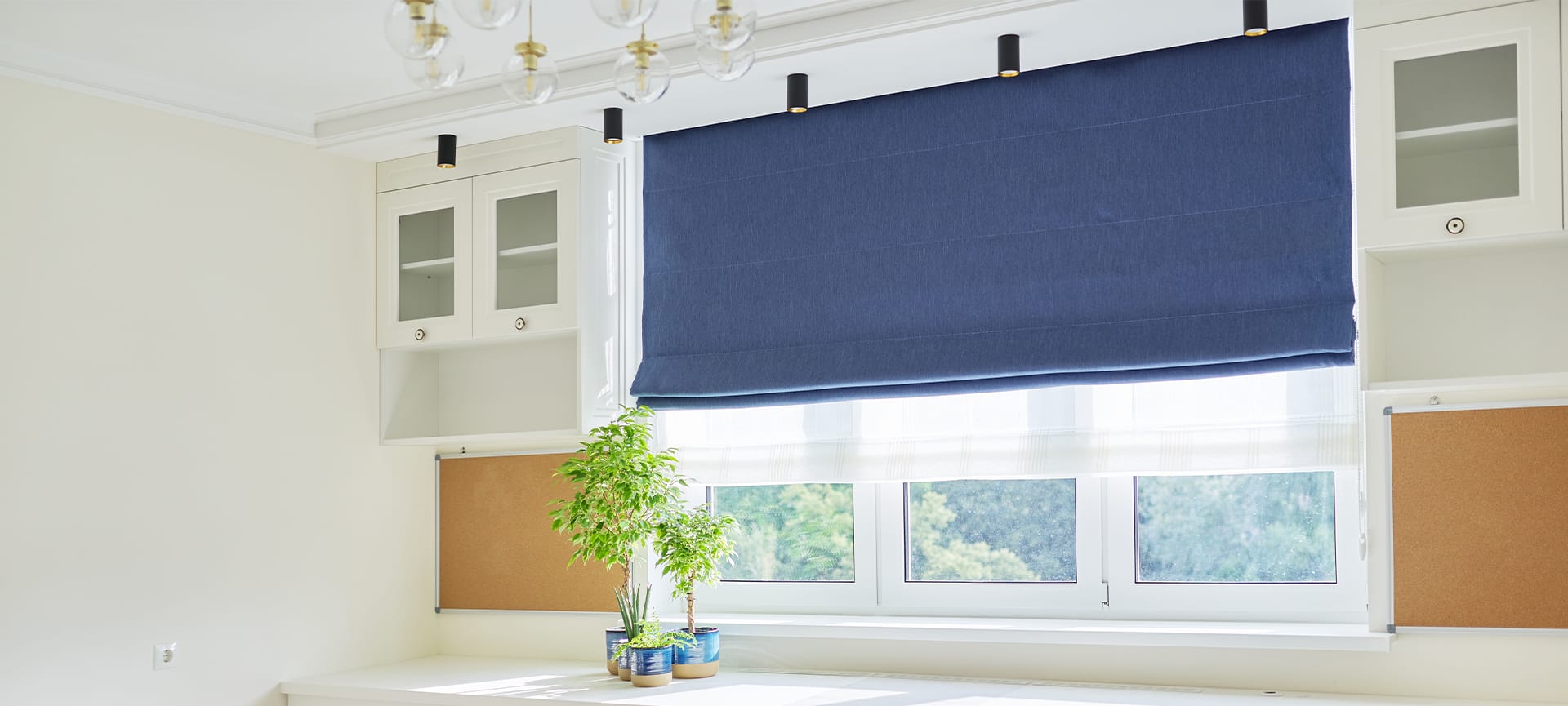 White furniture, table, blue roman blind on the window