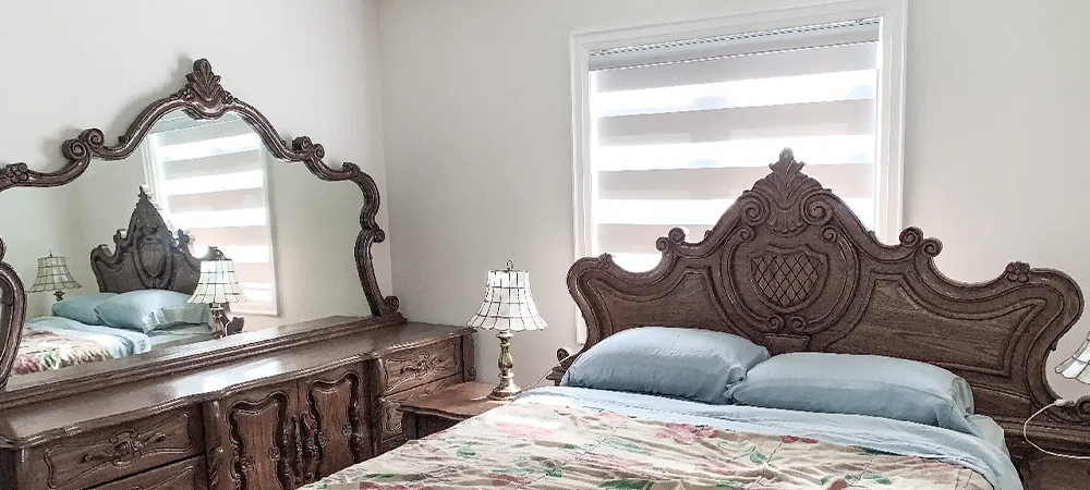 zebra blind on small window behind wooden bed and room wooden furniture