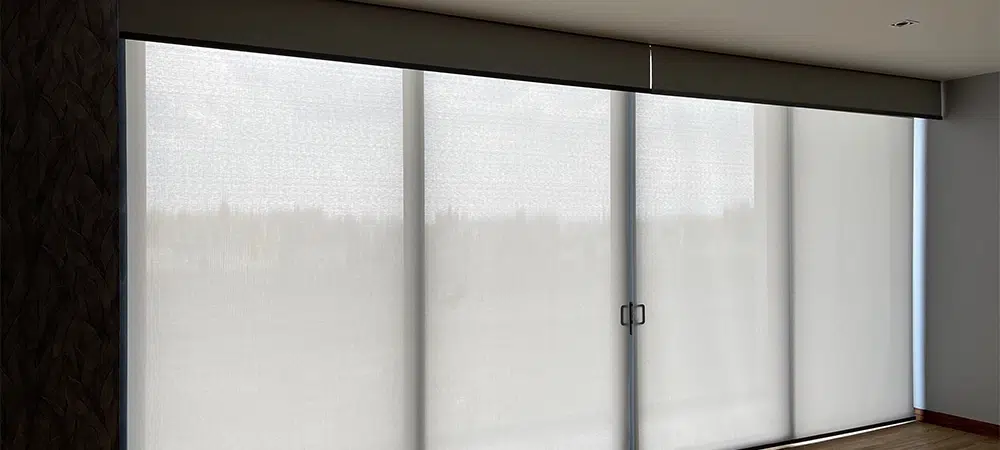Elegant shades with roller blinds in a big window. Wood textures and soft colors in decoration.