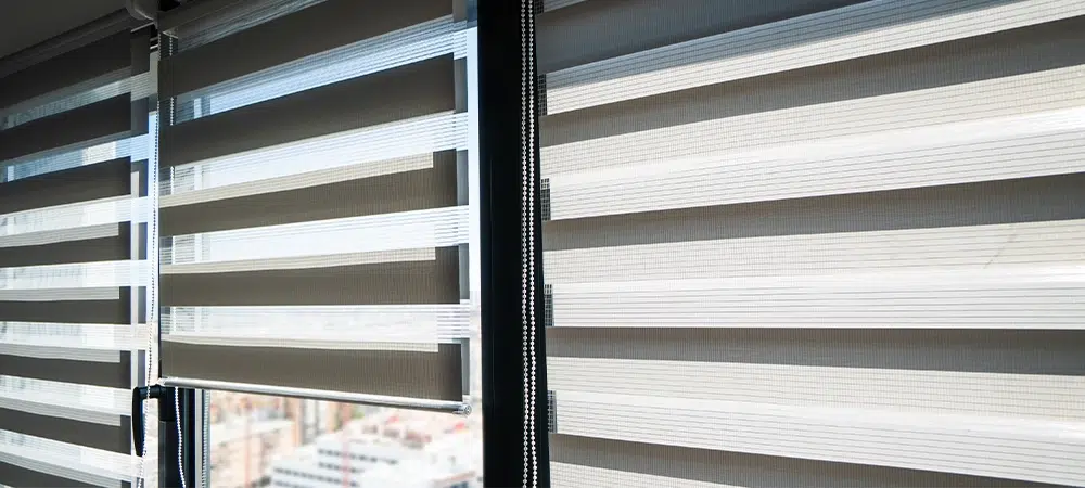 Striped zebra roller blinds on large windows providing adjustable light control in modern bright interior