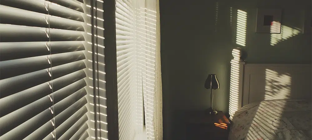 Rays of Sunlight Through Window Blinds in Bedroom