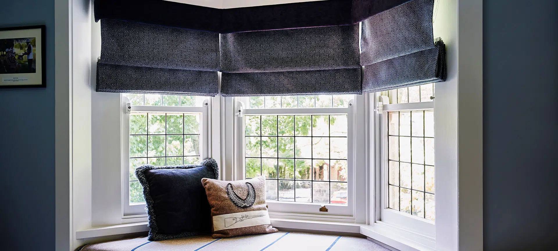 Interior photography of a bay window with banquette seat and cushions in a Victorian home