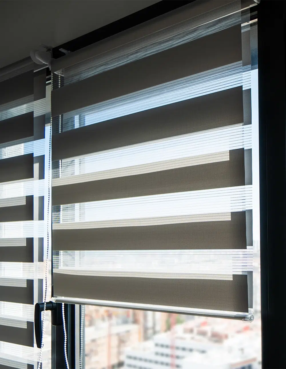 Striped zebra roller blinds on large windows providing adjustable light control in modern bright interior