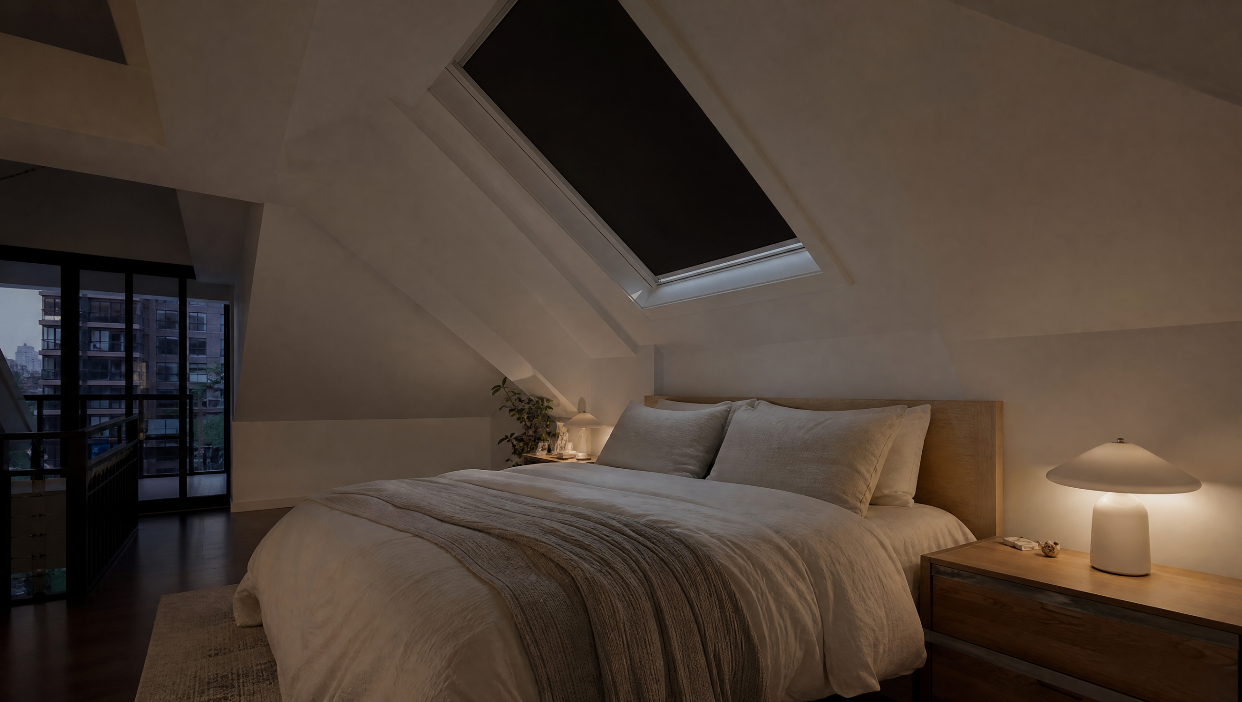 Blackout skylight shade nearly closed over a roof window in a dim modern Toronto loft bedroom