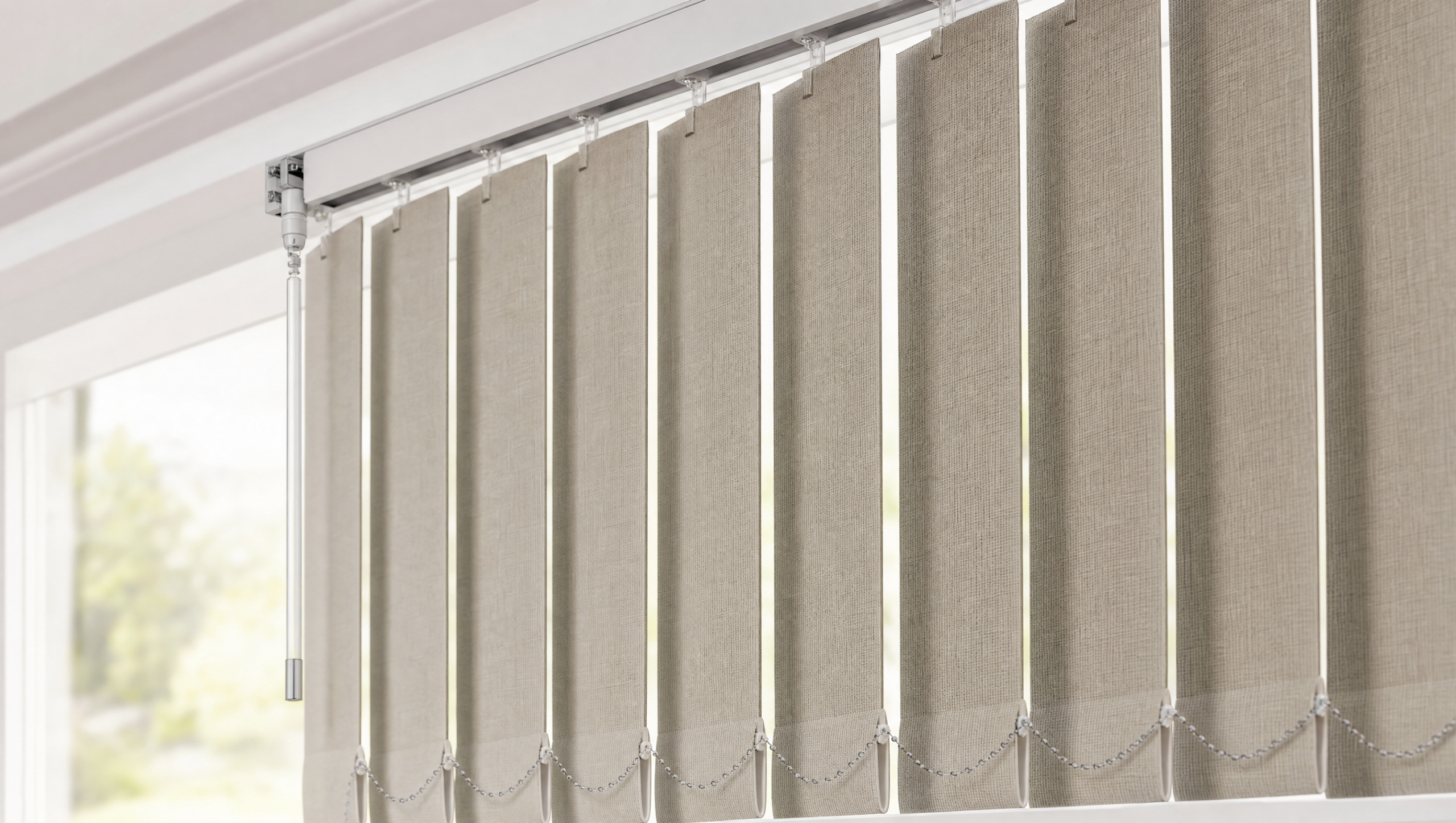 Close-up of greige fabric vertical blind vanes hanging from a headrail track with a control wand